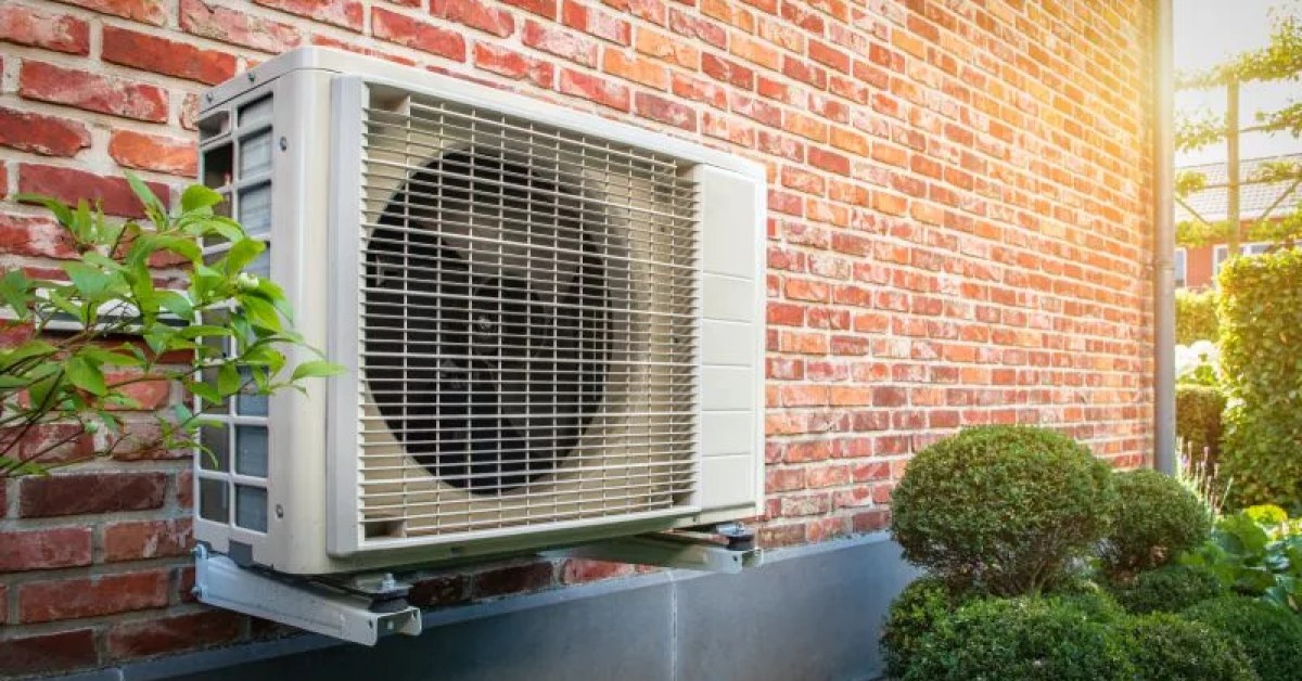 Residential heat pump equipment beside a home